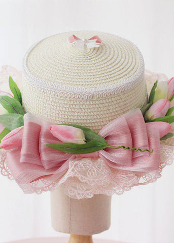 Eleganter rosa Glockenhut mit Schleife und Spitze im Patchwork-Stil aus gewebtem Stroh